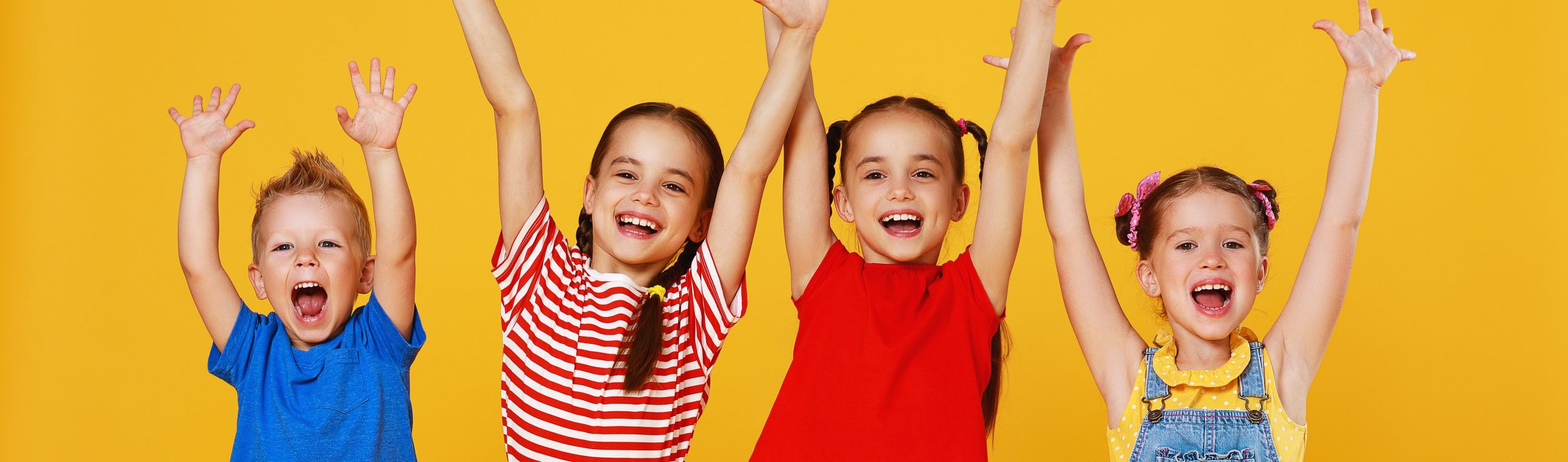 group of cheerful happy children on colored yellow background