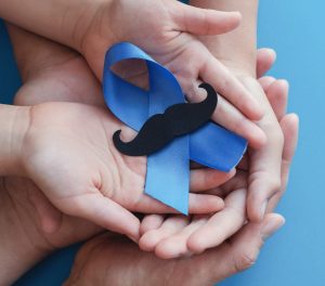 Family hands holding light blue ribbonwith mustache on blue back